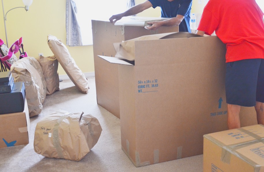 Two people unpacking moving boxes